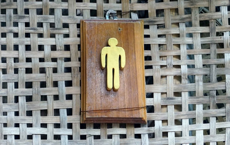 A wooden man sign on the wall in classic woven wood stlye.の写真素材