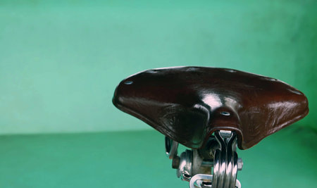Close up of a vintage  bicycle seat on green background for texture and backgrounds.の写真素材