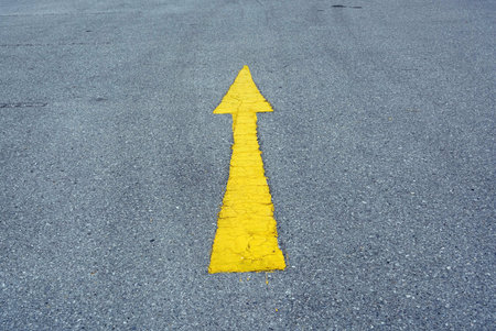 A yellow arrow on the road, conceptual image of business direction.の写真素材