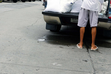 A man taking a white bag ice on the car for delivery to customers