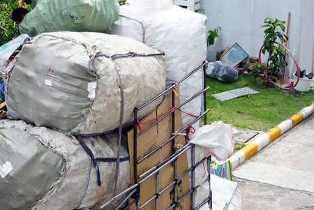 A collect garbage bags up on the car to recycle beside a garden of the condo.の写真素材