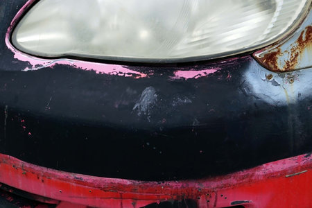 Detail of the headlight of an old body car with cracked paint and rust for texture and background.の写真素材
