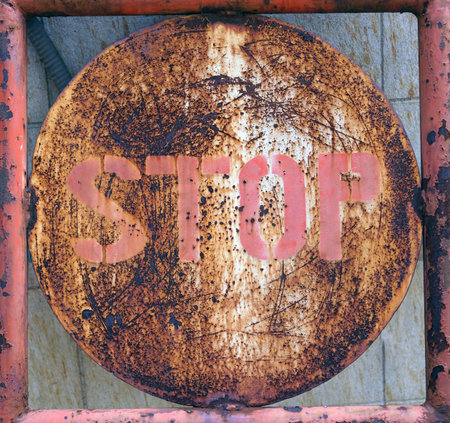 Stop sign on a rusty metal fence, conceptual image for danger.の写真素材