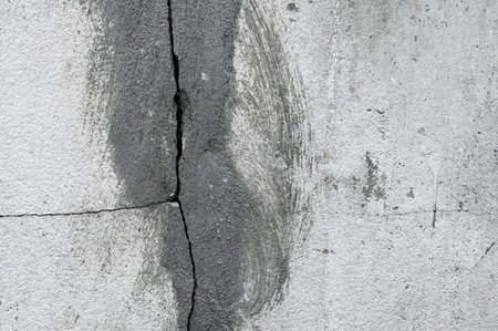 A vertical cracks on the old vintage white concrete wall, abstract background and texture.