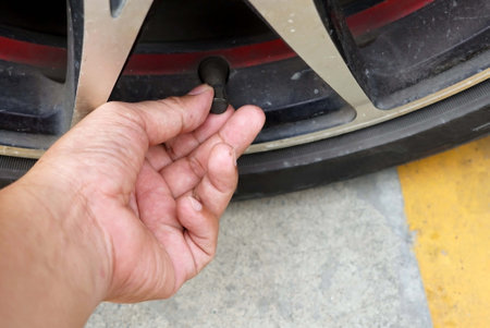 Close up of a hand was take of a tire inflator car wheel on the road to filling a inflate.の写真素材