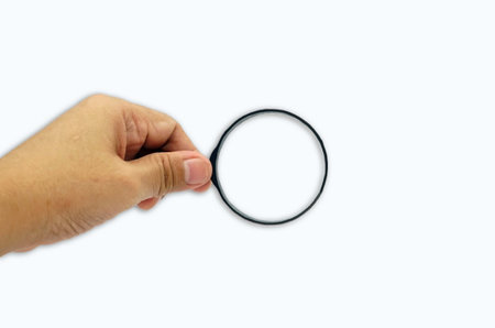 Magnifying glass in hand isolated on white background with clipping path, finding concept.の写真素材