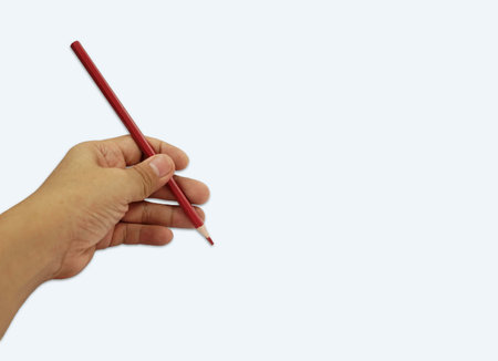 A red pencil in hand isolated on a white background with copy space,     
designer conceptual for creative.の写真素材
