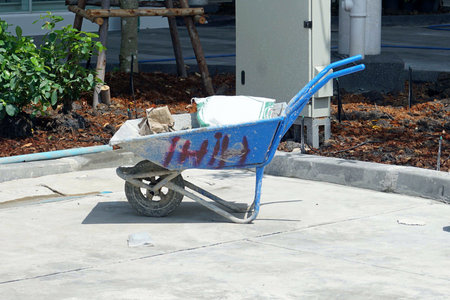 A blue wheelbarrow for construction work at the construction site.の写真素材