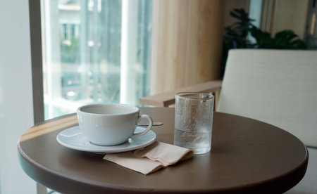 Coffee cup and water on table in coffee shop, stock photo.の写真素材