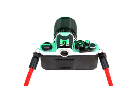 A backside of a retro film camera with red strap isolated on white background, retro vintage concepts.の写真素材