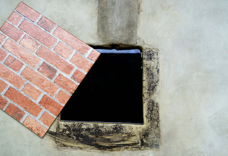 Close up top veiw of a waste water with cover open in the cement floor.の写真素材