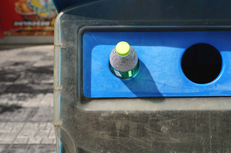Close-up of a plastic bottle put in a blue recycling bin, environment concepts.の写真素材