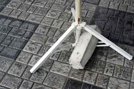 white collapsible pole with concrete block on paved surfaceの写真素材