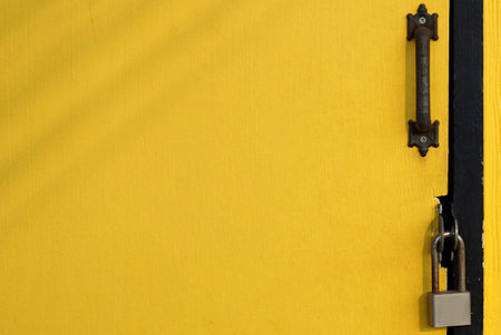 A wooden yellow door with a padlock for placing thingsfor background and texture, design small shop concepts.の写真素材