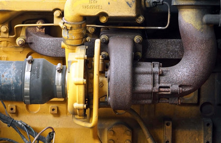 Close up a Engine exhaust pipe set of the old vintage yellow engine of a generator.