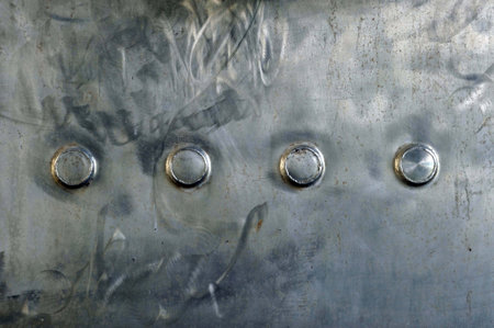 Metal texture with rivets, close-up, industrial background.の写真素材