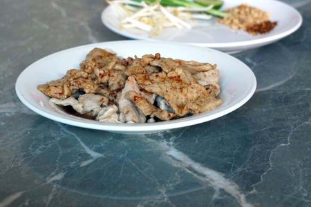 Fried pork with garlic in white dishle table background.の写真素材