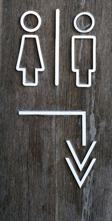 Male and female toilet sign on old wooden background, facility concepts.の写真素材