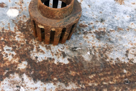 Rusty old metal gear on the background of a rusty iron sheet.