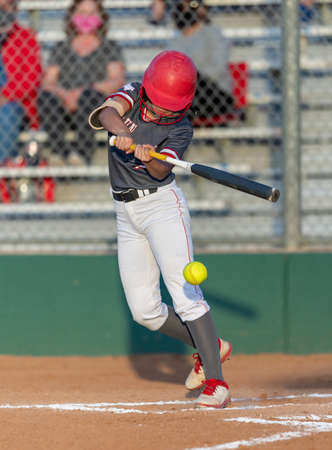 Young athletic girls making exciting plays during a Softball game