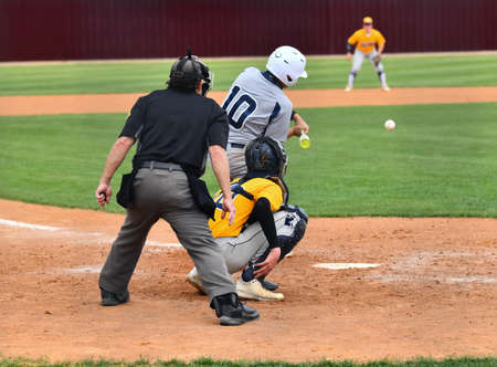 Action photo of high school baseball players making amazing plays during a baseball gameの写真素材