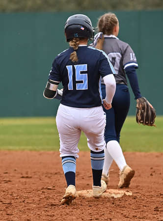 Athletic girls in action playing in a softball game