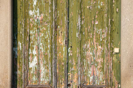 Close-up of an old door with peeled and weathered woodの写真素材