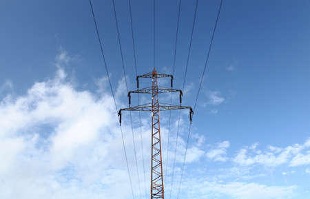 Power line tower against blue sky