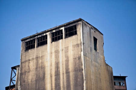 Old abandoned concrete building against blue sky in former steel mill in Ostrava, Czech Republicの写真素材