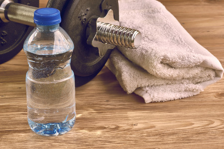 Fitness workout, slimming exercises, weight loss and healthy eating concept, dumbbells, bottle of mineral waterの写真素材