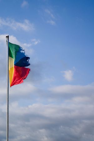 Flag with colors of the peace in the blue sky