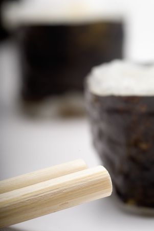 Composition of maki sushi, white late and a stick. Close focus and shallow depht of field usedの写真素材