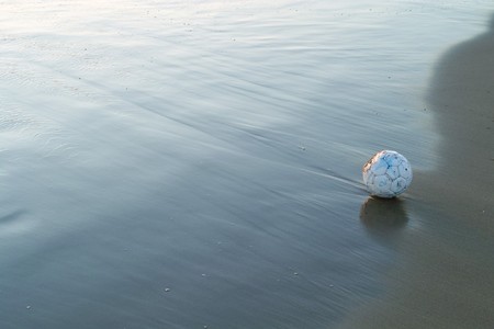 Soccer Ball near the sea at sunsetの写真素材