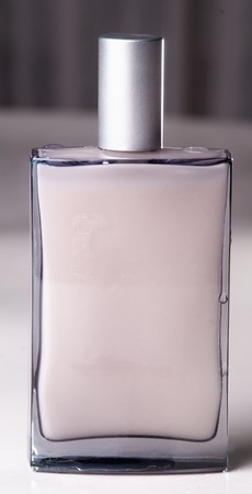 Detail of a classy Bottle Of Parfum on a metallic-pink blurred backgroundの写真素材
