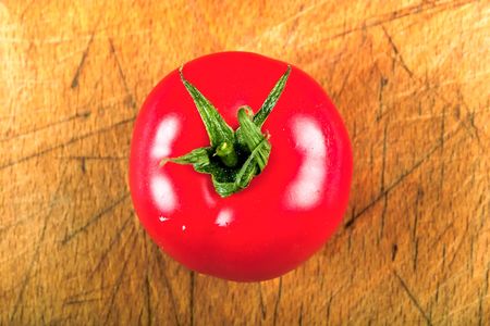 Close up of fresh tomato on a wood plate.の写真素材