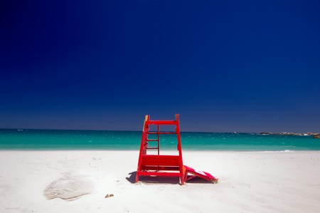 Red safeguard cabin isolated in the beautiful beach of camps bay with a marvelous emerald sea in the background in cape townの写真素材