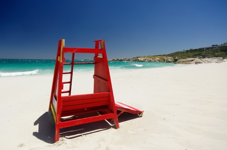 Red safeguard cabin isolated in the beautiful beach of camps bay with a marvelous emerald sea in the background in cape townの写真素材