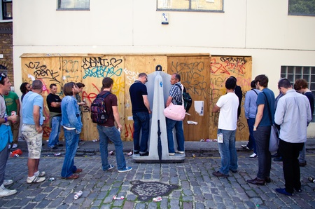 LONDON - AUG 28: men queue up at a opne-sky toilet during the  Notting Hill Carnival on August 29,...