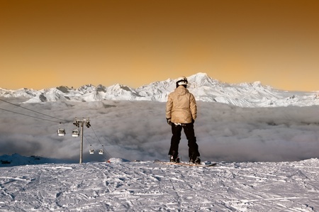 Snowboarder admiring the panorma before forsome surfing in the courchevelの写真素材