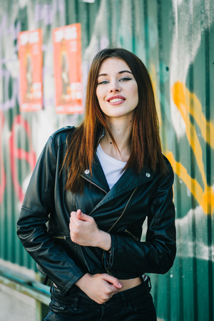 Young beautiful brunette walk in a city against a grundge backgroundの写真素材