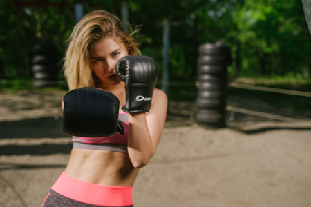 Confident girl training boxe  in a open public gym, dramatic light with lot of contrast to emphasize the modelの写真素材