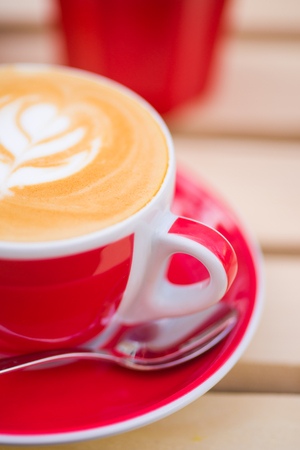 Close-up of cup of Cappuccino coffee with some cool design on the foamの写真素材