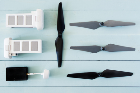 Top view of drone components, included propellers, video link, digital transmitter and screwdriver  on a rusty blue background wooden tableの写真素材