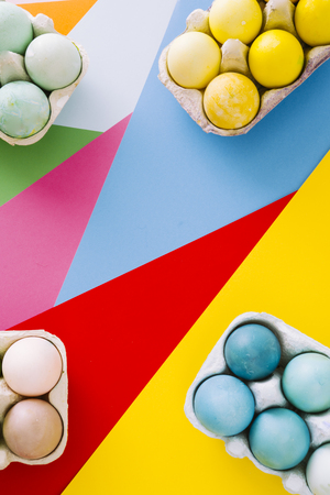 Dyeing eggs for Easter holidays, colored eggs in the tonality of yellow and blue are displayed over...