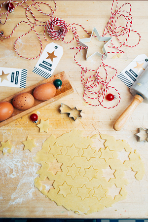 Preparing Christmas cookies as gift, with christmas ribbon gift's over a black background, top view.の写真素材