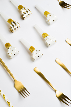 Top view of a composition celebrating the new  year, with golden cutlery, champagne bottle, whistle and golden white straw, luxury new year, top view.の写真素材