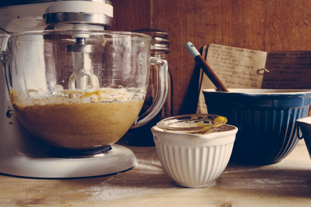 Ingrediens are mixed  to prepare some pumpkin muffin for halloween are displayed, frontal view, with...
