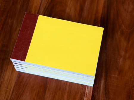 Yellow color bill books or receipt books on a wooden surface, close up shotの写真素材