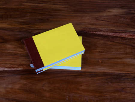 Yellow color bill books or receipt books on a wooden surface, close up shotの写真素材