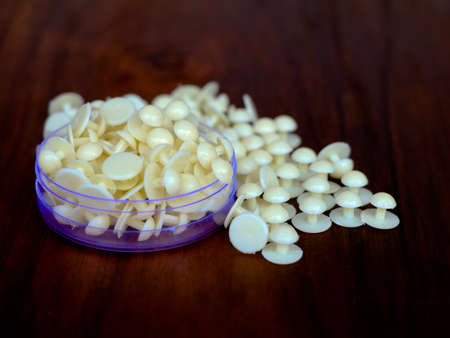 Cream color buttons of cassock against wooden background, selective focusの写真素材